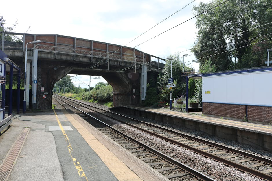 A view of a railway station platform near Upminster Bridge Station RM14, showing two set of train tracks running parallel along the platform with tactile paving along the edge for safety. The platform
